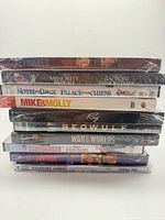 Stack of eight sealed DVDs showing spines for title identification