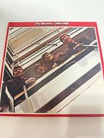Front cover with red border and early Beatles stairwell photo