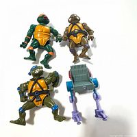 Three TMNT figures and rolling accessory laid out