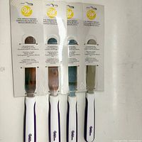 Front view of four packaged Wilton 11 in straight spatulas