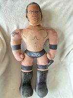 Front view of WWE The Rock plush showing details and tag