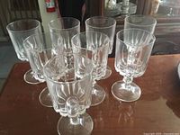 Set of 10 clear crystal white wine glasses arranged in a cluster, showing their overall shape, height, and faceted stems.