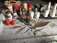 Overview of all 10 sets of salt and pepper shakers laid out on a table showing different materials and conditions.