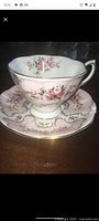 Side view of Royal Albert Rose du Barry Series Camille cup and saucer showing floral design and gold trim.