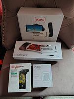Photo showing all four boxes: Movi smartphone stabilizer, GAMEVICE controller, OlloClip iPhone lens, and Quo selfie ring light mirror.