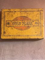 Top of the vintage yellow metal rectangular tin showing the Gold Flake Honey Dew brand name and decorative border with signs of wear and aging.