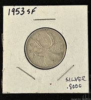 Reverse side of the 1953 Canadian 25 cents coin in a white cardboard holder showing the year 1953, a caribou, and silver content marking of .8000.