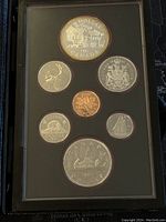 Photo of all seven coins in the proof set displayed in a protective plastic case with black background.