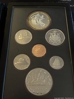 Full view of all coins in the 1983 Canadian proof set including the silver double dollar and other denominations, all with proof finish in a fitted black case.