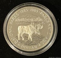 Reverse side of 50% silver coin featuring a moose with forest and mountain background, commemorating National Parks 1885-1985.