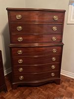 Front view of bow-front chest showing all six drawers and brass handles