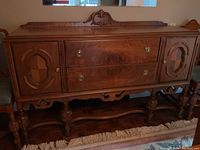 Front view of entire wooden hutch showing detailed carvings, doors, and drawers.