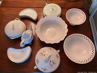 Overview photo showing 12-inch ceramic serving items including lidded bowls, large serving bowl, teapot, pierced bowls, and kidney-shaped plates