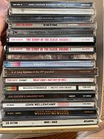 Stack of 17 music CDs showing album spines and artist names.