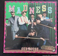 Front cover of Madness 12-inch vinyl maxi-single 'Our House' with band photo and colorful title lettering.