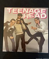 Front cover of Teenage Head vinyl album showing band members and stylized title.