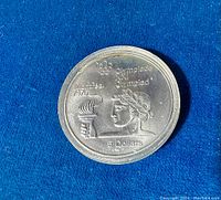 Reverse showing Olympic torch, athlete profile, Montreal 1976, Olympiade XXI Olympiad and 5 Dollars inscription