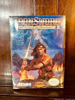 Front of Nintendo NES game Iron Sword Wizards & Warriors II box showing artwork and branding.