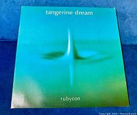 Front cover of Tangerine Dream Rubycon vinyl LP, showing album title and band name on green gradient background.