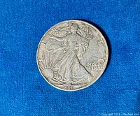 Obverse side showing Walking Liberty design and date 1987 on blue background.