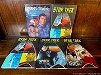 Full view of five Star Trek graphic novels including The Best of Star Trek softcover and four hardcover comic books including Star Trek Countdown (two copies), Spock: Reflections, and Starfleet Academy.