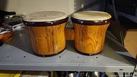 Pair of wooden bongo drums front view showing connected wooden body and natural skins.