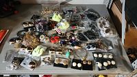 Top-down view of assorted costume jewelry with earrings, bracelets, and brooches spread out on a tabletop.