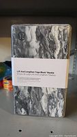 Front view of the marble patterned Lululemon yoga block in packaging.