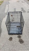 Full view of the Pet Mate medium sized dog cage showing black metal wire structure and door.
