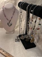 Photo of all 6 vintage AVGAD marked necklaces displayed on necklace stands and surface.