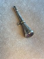 Overall view of the silver watch key showing tapered shape, hand engraving and purple glass inlay.