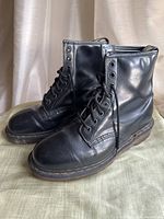 Profile view of black leather Doc Martens boots showing overall good condition and lace-up front