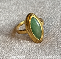 Close-up front view of ring showing marquise jade stone and gold bezel