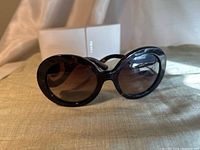 Front view of sunglasses with case in background