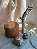 Full view of jewelry display hand, wooden boxes, heart-shaped box, and small blue box with jewelry pieces.