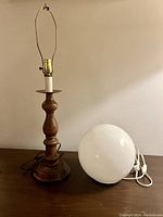 Both wood based lamp and white spherical lamp seen together, showing size and shape.