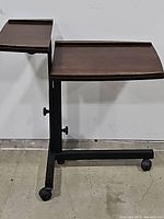 Side view showing two wooden trays at different heights supported by a metal frame with caster wheels.