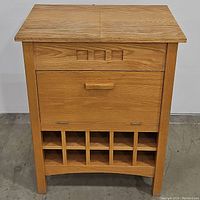 Front view of wooden bar console cabinet with closed top, drawer, and wine rack below