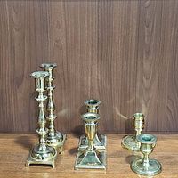Photo of all six brass candlestick holders showing various sizes and designs