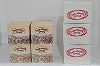 Stack of seven David Winter Cottages branded boxes with illustrated village scenes.