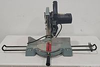 Top down front view of the Delta miter saw showing the base with angle adjustment markings and extendable fences.