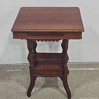 Front view of oak carved parlor/center table showing rectangular top and detailed carved legs and supports.