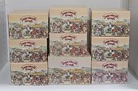 Nine boxes for David Winter cottages arranged in three piles of three, showcasing branding and artwork on the boxes.