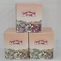 Three boxed David Winter Cottages with detailed illustrated packaging showing village scenes and the David Winter logo.
