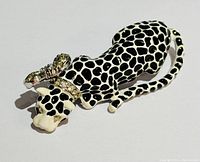 Kenneth Lane leopard brooch front view showing black and white enamel spots and rhinestone bow detail.