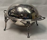 Front angle view of the closed roll top breakfast server showing the embossed dome lid and ornate legs with claw feet.