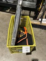 Yellow plastic basket containing a foldable reflective sunshade and compact emergency kit in black and orange case