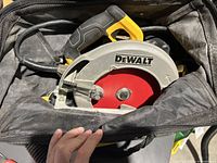 Dewalt corded circular saw visible inside the carry case with red blade and yellow handle