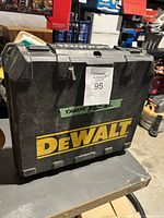 Closed black hard plastic carry case with DeWalt logo and a label indicating it was tested.
