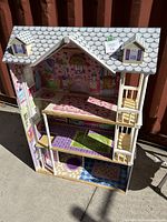 Front view showing the three floors, patterned interiors, and roof design with dormer windows.